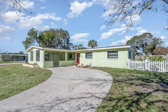 single story home featuring a sunroom and a front yard