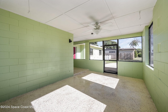 unfurnished sunroom featuring ceiling fan