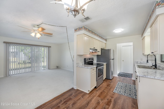 kitchen with appliances with stainless steel finishes, a textured ceiling, dark wood-type flooring, and sink