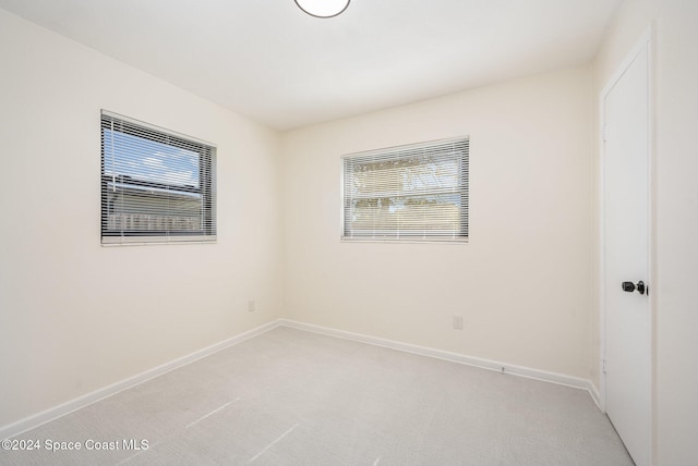 spare room with light carpet and a wealth of natural light