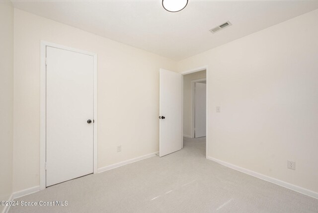 unfurnished room featuring light carpet