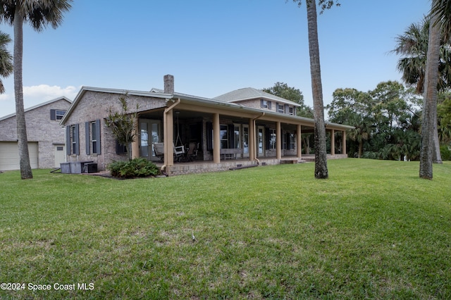 back of house featuring a lawn and a porch