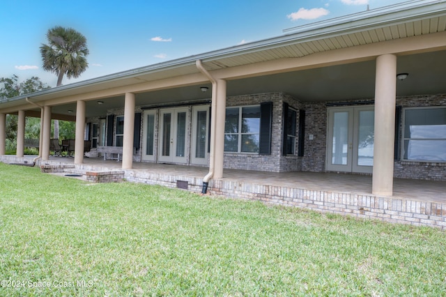 back of house featuring french doors and a lawn