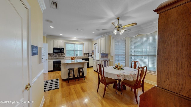 dining room featuring light hardwood / wood-style flooring, ceiling fan, crown molding, and sink