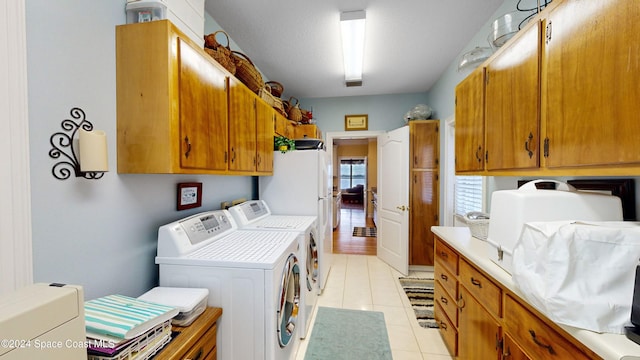 laundry room featuring cabinets, separate washer and dryer, and light tile patterned flooring