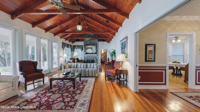 living room with wooden ceiling, lofted ceiling with beams, hardwood / wood-style flooring, ceiling fan, and a fireplace