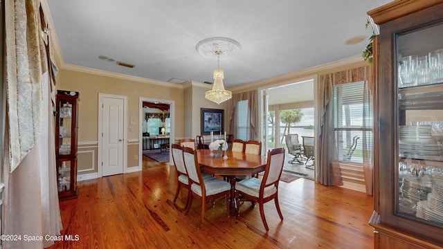 dining room featuring crown molding, a chandelier, and hardwood / wood-style flooring