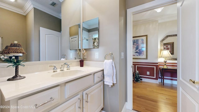 bathroom with hardwood / wood-style floors, vanity, and ornamental molding