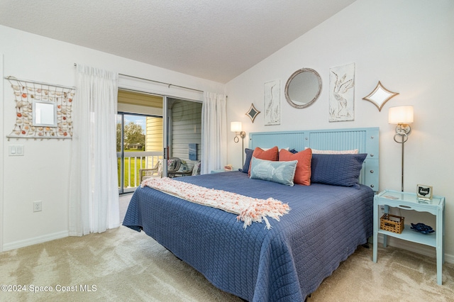 bedroom featuring a textured ceiling, access to exterior, carpet floors, and lofted ceiling