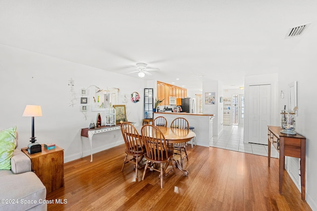 dining area featuring ceiling fan and light wood-type flooring