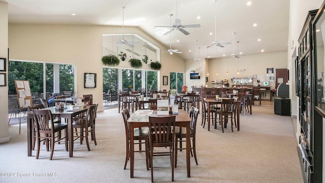 carpeted dining area featuring high vaulted ceiling