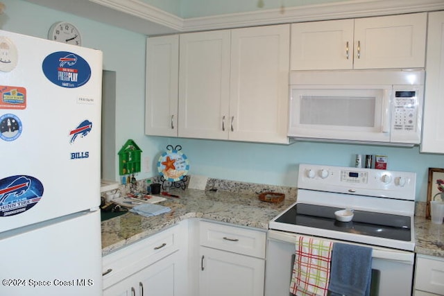 kitchen with white cabinetry, light stone countertops, and white appliances