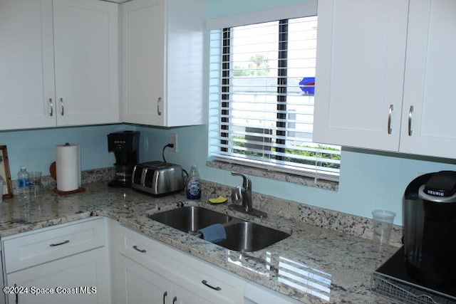 kitchen featuring plenty of natural light, white cabinetry, and sink