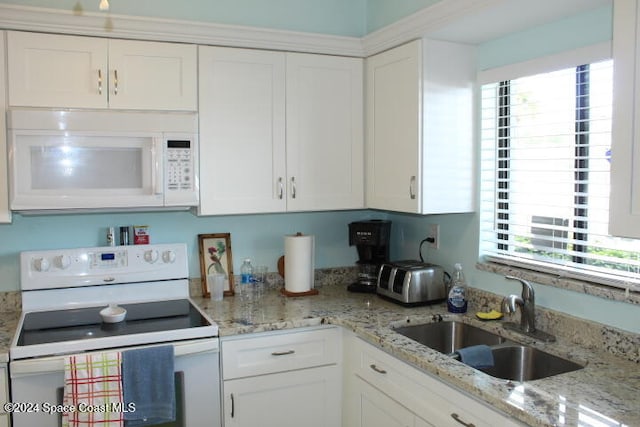 kitchen with white cabinets, plenty of natural light, white appliances, and sink