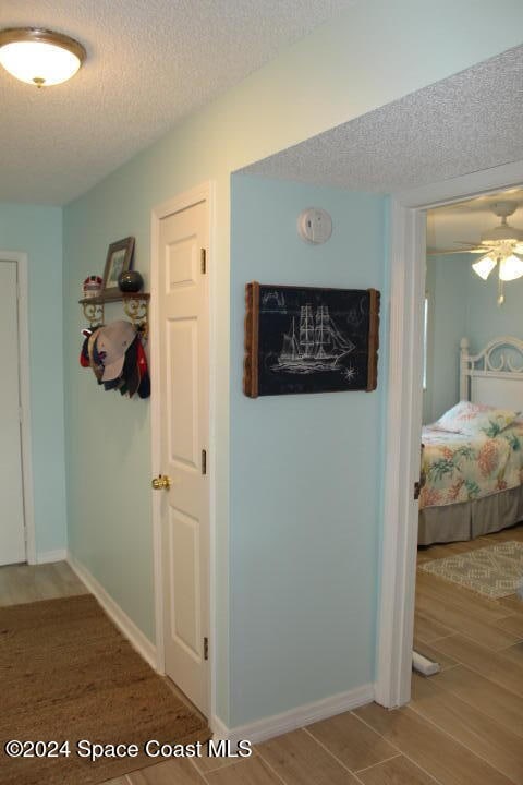 hallway featuring hardwood / wood-style flooring and a textured ceiling