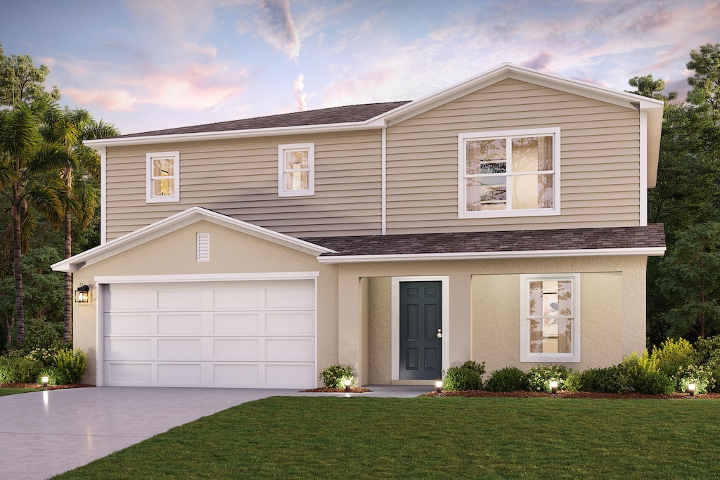 view of front of home with a garage and a yard