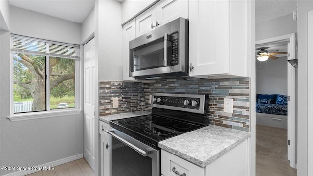 kitchen with a healthy amount of sunlight, white cabinetry, appliances with stainless steel finishes, and tasteful backsplash