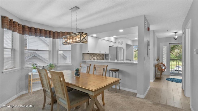 carpeted dining space with a textured ceiling