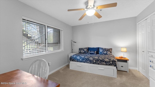 carpeted bedroom featuring a closet and ceiling fan