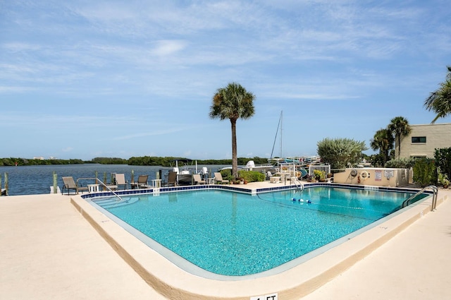 view of pool with a patio area and a water view