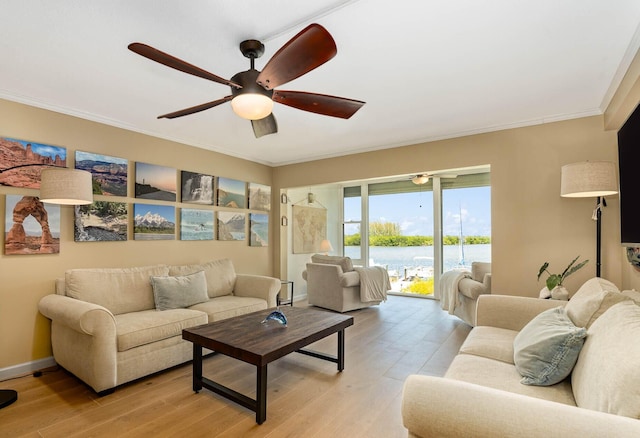 living room featuring light hardwood / wood-style floors, ceiling fan, and ornamental molding