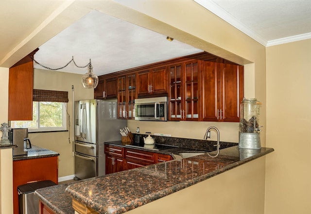 kitchen featuring sink, hanging light fixtures, dark stone countertops, kitchen peninsula, and stainless steel appliances