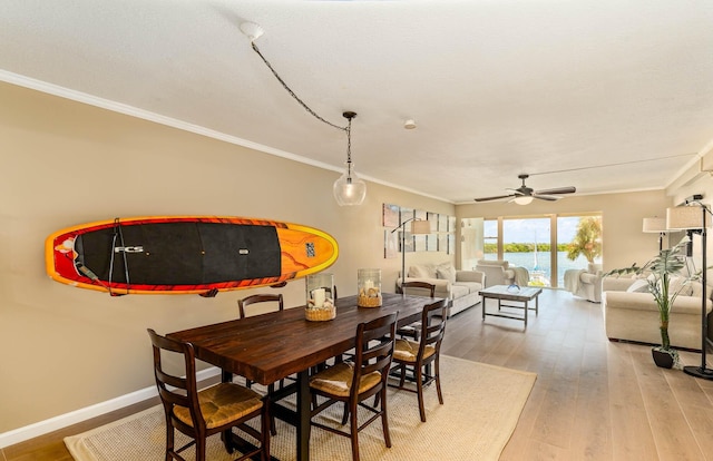 dining space with hardwood / wood-style flooring, ceiling fan, and crown molding