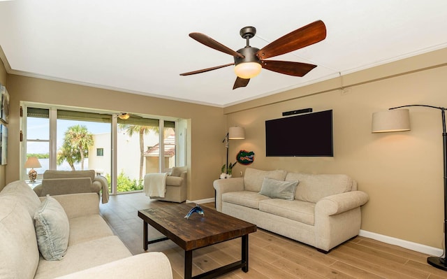 living room with ceiling fan, light wood-type flooring, and crown molding