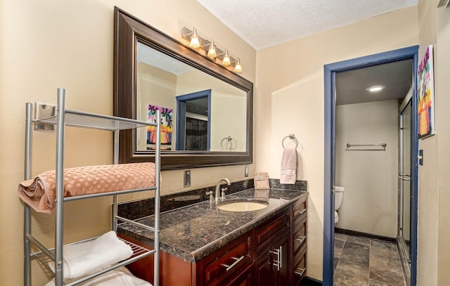 bathroom featuring vanity, a textured ceiling, and toilet