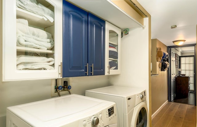 laundry room featuring washer and clothes dryer, dark hardwood / wood-style flooring, and cabinets