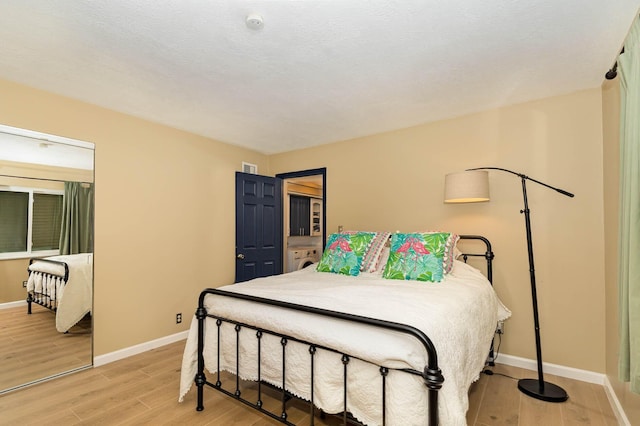 bedroom featuring light hardwood / wood-style flooring and a textured ceiling