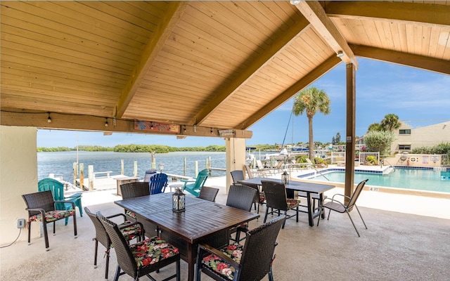 view of patio featuring a community pool and a water view