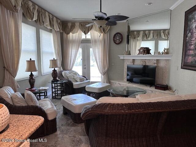 living room with a fireplace, ceiling fan, and french doors