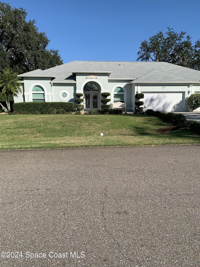 view of front of home with a garage and a front lawn