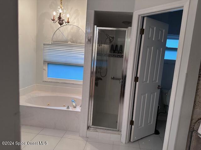 bathroom featuring an inviting chandelier, tile patterned floors, and separate shower and tub