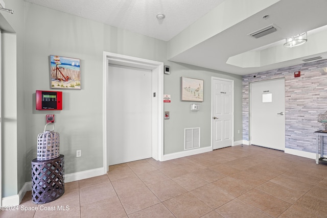 tiled foyer featuring a textured ceiling