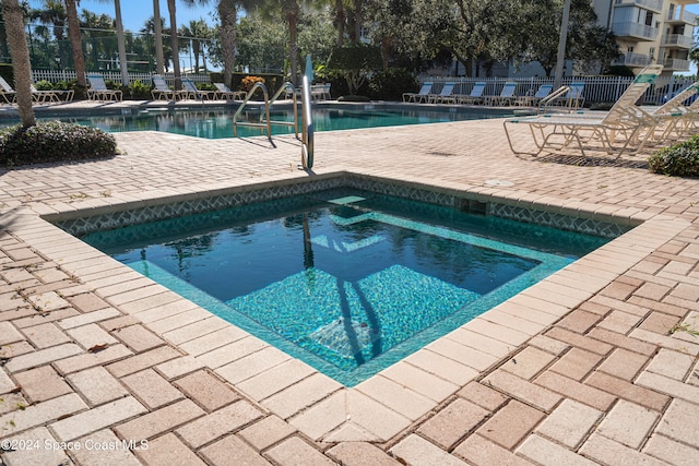 view of swimming pool with a patio area and a community hot tub