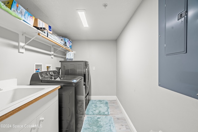 laundry room featuring hardwood / wood-style floors, sink, and washing machine and clothes dryer