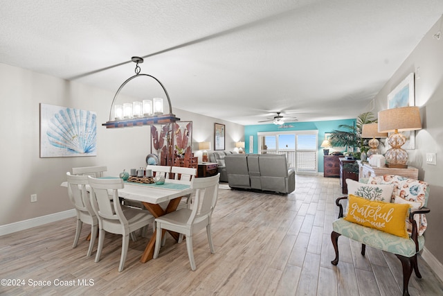 dining space with ceiling fan, a textured ceiling, and light wood-type flooring