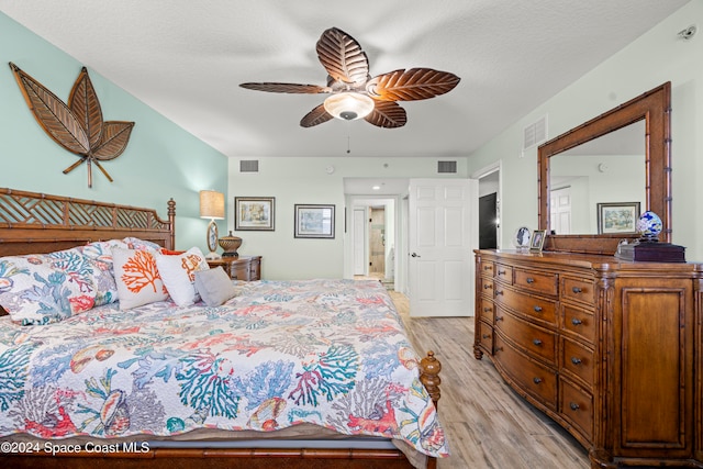 bedroom with ceiling fan, a textured ceiling, and light hardwood / wood-style flooring