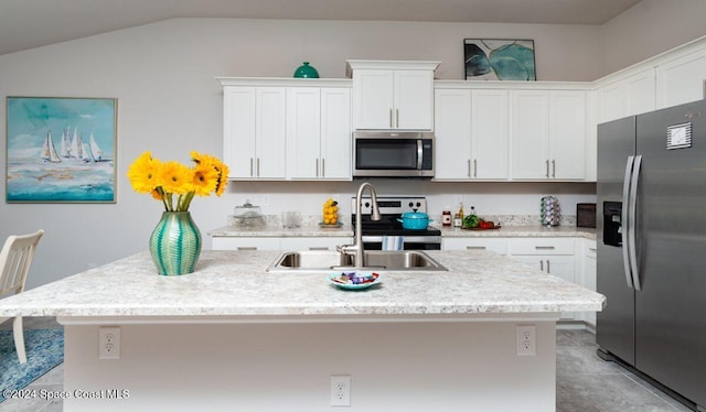 kitchen featuring sink, stainless steel appliances, lofted ceiling, a center island with sink, and white cabinets