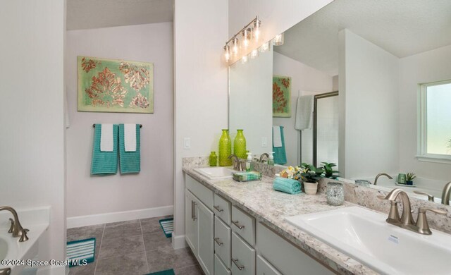 1654 Middlebury Dr SE, Palm Bay, FL 32909 - full bath featuring double vanity, a garden tub, a stall shower, baseboards, and tile patterned flooring