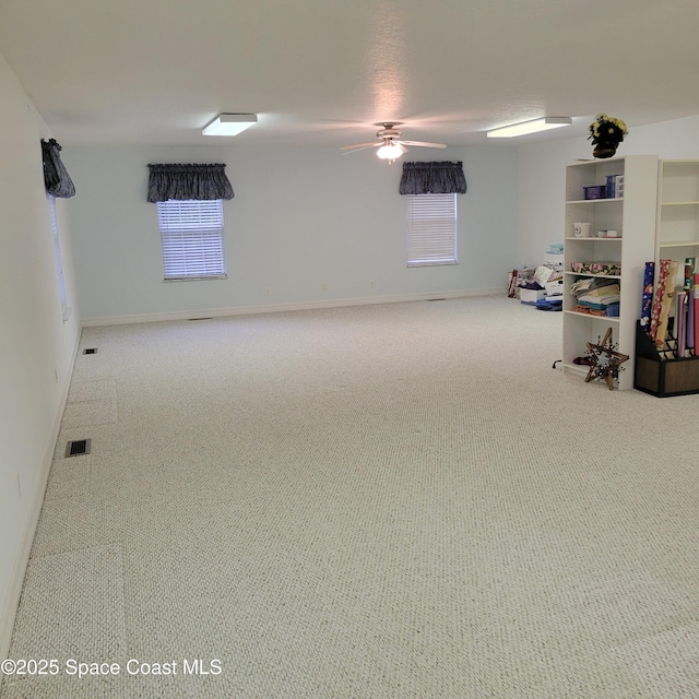 basement featuring ceiling fan and carpet