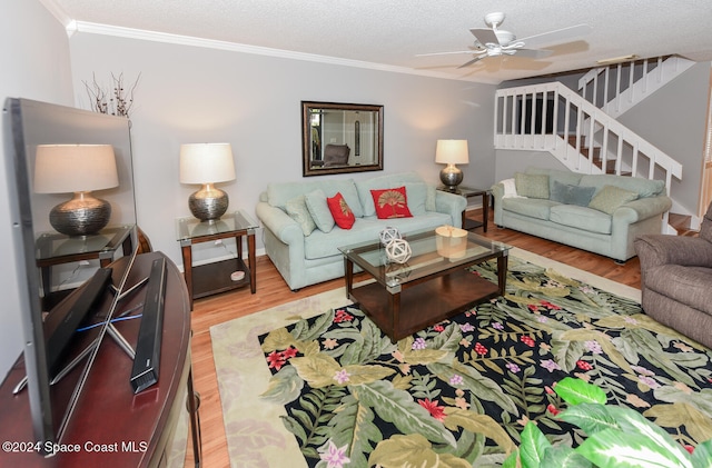 living room with ceiling fan, ornamental molding, a textured ceiling, and hardwood / wood-style flooring