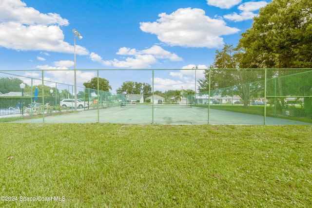 view of sport court featuring a yard