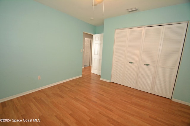 unfurnished bedroom with ceiling fan, a closet, and light hardwood / wood-style flooring