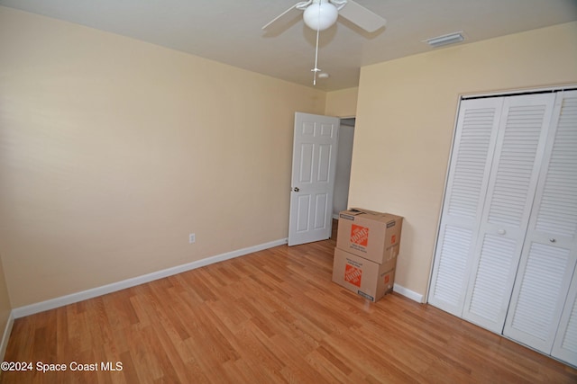 unfurnished bedroom featuring ceiling fan, a closet, and light hardwood / wood-style flooring