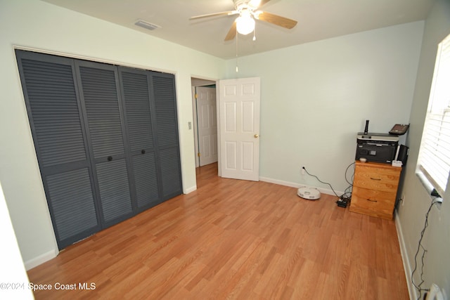 unfurnished bedroom with light hardwood / wood-style floors, a closet, and ceiling fan