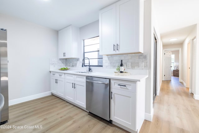 kitchen featuring light wood-type flooring, stainless steel appliances, and white cabinetry