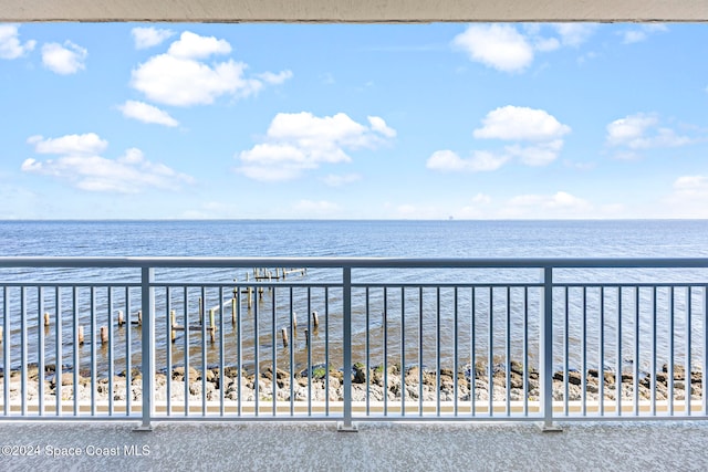 balcony featuring a beach view and a water view